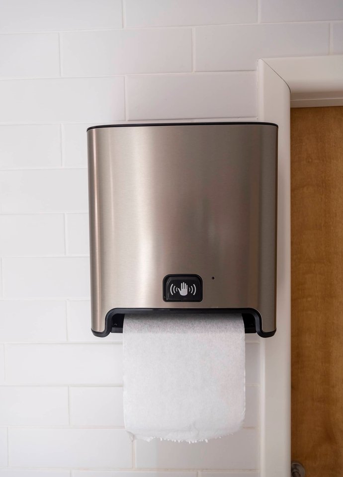 Stocked paper towel and soap dispensers in a commercial washroom.