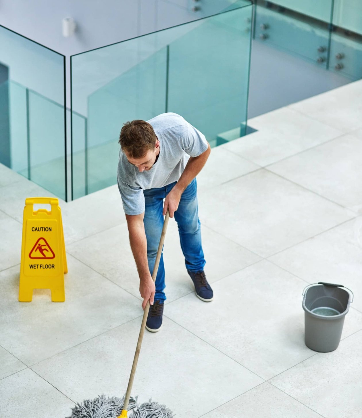 Cleaner mopping a commercial stairwell.