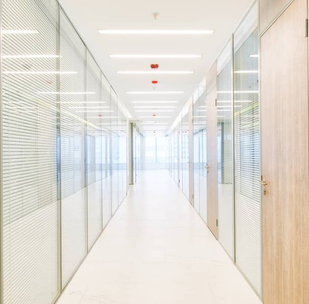 Long office corridor with glazed partitions and timber detailing.