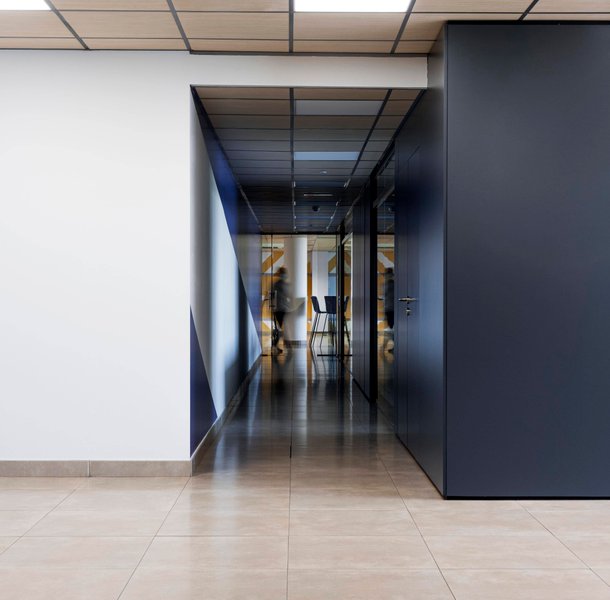 Clean commercial hallway with tiled flooring and dark feature wall.