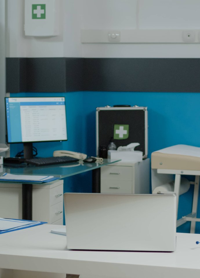 Clinical consulting room with medical equipment.