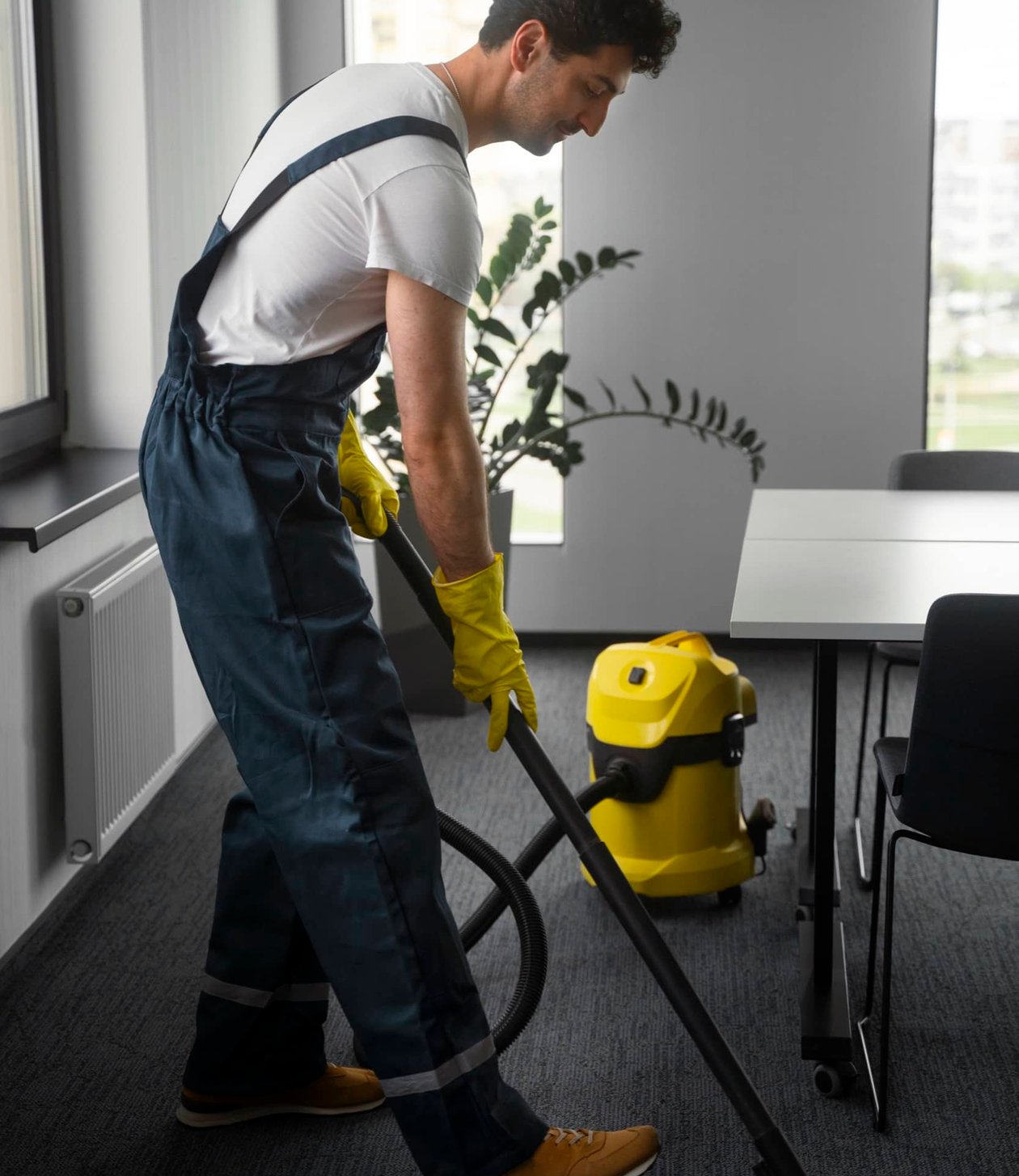 Cleaner vacuuming an open plan office after hours.